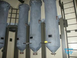 Filtration, Filtern:
(filtration) Filtern ist ein mechanisches Trennverfahren, um eine Suspension in seine Bestandteile Feststoff und Fl�ssigkeit zu trennen. Als Filtermaterial wird z.B. Quarzsand verwendet. Besondere Bedeutung kommt der Aktivkohle zu. 

Je nach Flie�geschwindigkeit des Wassers im Filter wird zwischen

    * Langsamfiltern (meist 0,1 bis 0,2 m/h) und 
    * Schnellfiltern (z. B. 15 m/h)

unterschieden.

Aufgrund ihres gro�en Fl�chenbedarfs werden Langsamfilter seltener gebaut. Schnellfilter gibt es mit offenen Becken oder mit geschlossenen Kesseln. Bei der Reinigung werden sie mit Wasser und/oder Luft r�ckgesp�lt. Um die Raumwirkung zu vergr��ern und die Laufzeit zwischen zwei Sp�lungen zu verl�ngern, werden Schnellfilter h�ufig als Mehrschichtfilter ausgef�hrt. 

Beim Zweischichtfilter beispielsweise besteht die obere Schicht aus einem leichteren Material gr�berer K�rnung (z. B. Filterkohle, Bl�hton, Bl�hschiefer oder Bims) und die untere Schicht aus einem schwereren Material feinerer K�rnung (in der Regel Quarzsand).

Filtrationsverfahren werden u.a. eingesetzt, um hohen Anforderungen an die Feststofffreiheit im Abwasser gerecht zu werden. Dabei erfolgt die Trennung von Partikel und Fl�ssigkeit durch eine Druckdifferenz zwischen den beiden Seiten des Filters, welche den Wassertransport durch den Filter erm�glicht. W�hrend des Filtervorganges werden die Feststoffe im Filter verdichtet und verringern somit das Porenvolumen, wodurch sich sowohl der Filterwiderstand als auch die Filtratqualit�t ver�ndern. Sobald der zul�ssige Filterwiderstand erreicht ist, muss der Filter r�ckgesp�lt und von den Feststoffen befreit werden.

Gel�ste Verbindungen k�nnen dagegen in herk�mmlichen Filtern nicht abgetrennt werden. Eine Ausnahme bildet allerdings die Biofiltration, wobei der Filter gleicherma�en als N�hrstoff f�r Bakterien dient und somit eine M�glichkeit des aeroben Abbaus bereits gel�ster organischer Verbindungen darstellt. 
Quelle: www.wasser-wissen.de
Filterhilfsmittel, Filtrationshilfsmittel:
Filterhilfsmittel werden einem Filtrationsprozess hinzugegeben, um die Filtration zu erm�glichen, erleichtern bzw. zu beschleunigen. 

Sie haben bei der Filtration die Aufgabe, 

    * Suspensionen mit nur wenig Feststoffanteil die Bildung eines Filterkuchens zu erm�glichen oder 
    * bei schleimigen Feststoffen den sich sonst daraus bildenden zu dichten und schwer durchl�ssigen Filterkuchen aufzulockern. 

Filterhilfsmittel werden entweder der zu filtrierenden Suspension unmittelbar zugesetzt oder vor der Filtration als Hilfsschicht auf dem Filter gebildet. Die gebr�uchlichsten Filterhilfsmittel sind Zellulose, Kieselgel, Kieselgur, Holzkohle u. Holzmehl. Sie wirken alle physikalisch-mechanisch und ver�ndern nicht die chemische Zusammensetzung der Fl�ssigkeit zumal sie weitestgehend unl�slich sind

Bei schwierigen Kl�rfiltrationen werden auch dem Filtrationsprozess von Abw�ssern Hilfsmittel zugegeben. Vor allem bei Abw�ssern wird versucht, sehr feine Teilchen durch Zugabe von Flockungshilfsmittel zu agglomerieren, worauf sich diese dann leichter abtrennen lassen. Da diese den Filterprozess erleichtern k�nnen, werden sie in manchen F�llen f�lschlicherweise auch als Filterhilfsmittel bezeichnet.
Quelle: www.wassert-wissen.de